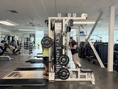 man lifting using squat rack in weight room