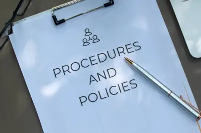 Documents labeled “Procedures and Policies” on a desk.