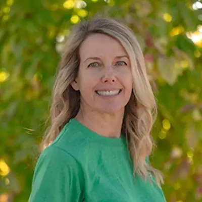 Ms Mandy, preschool supervisor, smiling outdoors.
