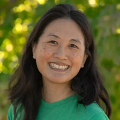 Ms Christine, preschool teacher, smiling outdoors.