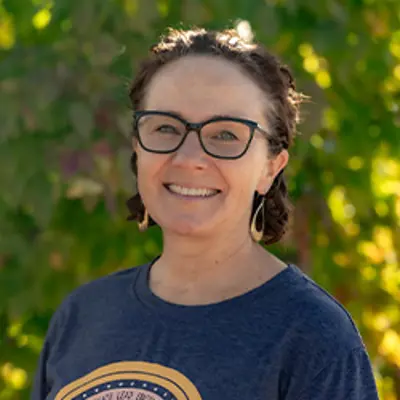 Ms Rebecca, preschool teacher, smiling outdoors.