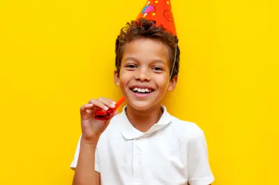 kid with a birthday hat and noise maker