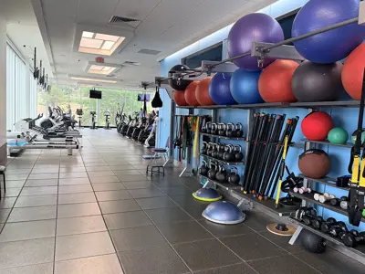 exercise equipment such as kettle balls and exercise balls along a blue wall