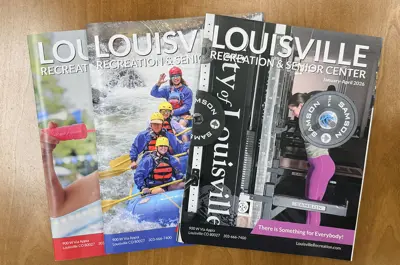 Louisville Recreation & Senior Center Catalogs displayed on a table.
