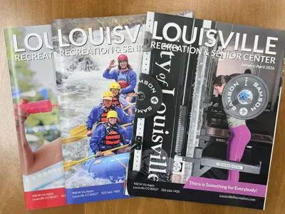 Louisville Recreation & Senior Center Catalogs displayed on a table.