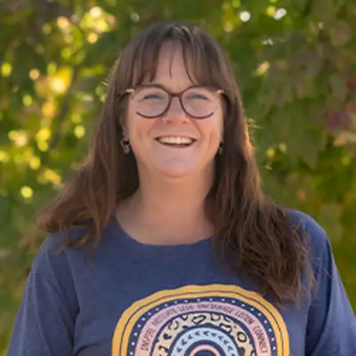 Ms Larissa, preschool teacher, smiling outdoors.
