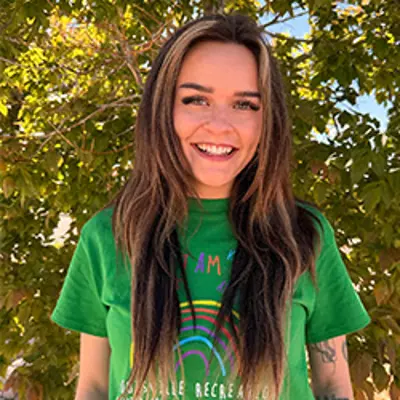 Ms Averi, preschool teacher, smiling outdoors.