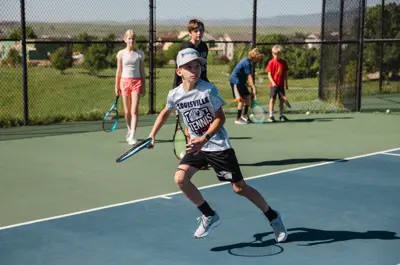 Young tennis player running to return a shot.