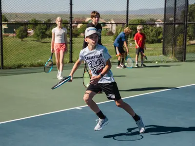 Young tennis player running to return a shot.