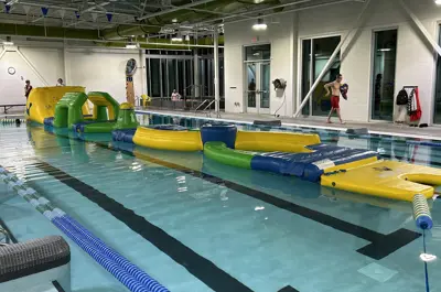 Indoor pool with a colorful inflatable obstacle course