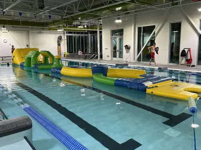 Indoor pool with a colorful inflatable obstacle course